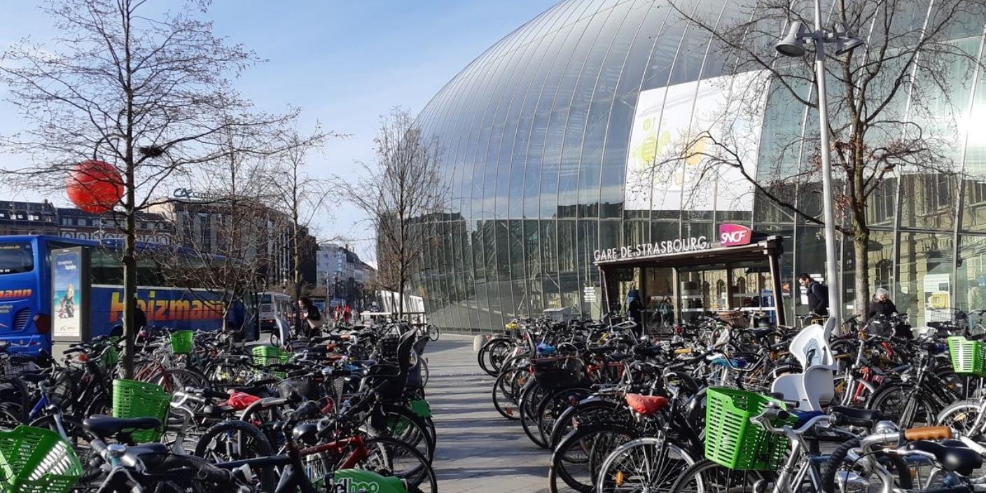 Vue de la gare de Strasbourg entourée d’une grande quantité de vélos stationnés, illustrant l’engagement de la ville pour la mobilité douce.