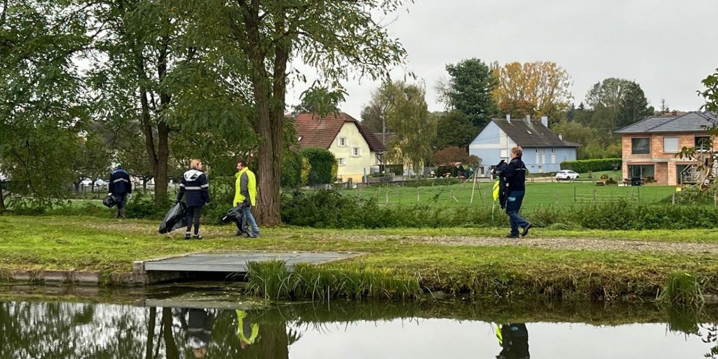 Des volontaires en gilets réfléchissants ramassent des déchets le long d’un cours d’eau près de Strasbourg lors d’une action écologique.