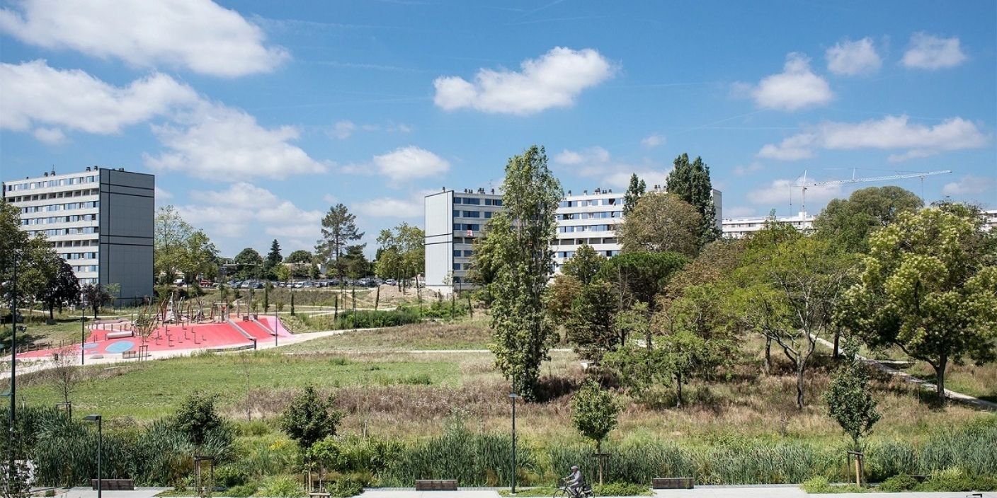 Vue d'un quartier écologique de Toulouse avec espaces verts et aire de jeux, symbolisant l'engagement urbain en faveur du développement durable.
